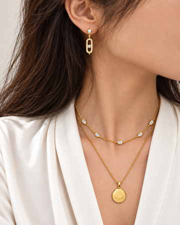 Model wearing gold earrings and layered necklaces for the Best Sellers collection