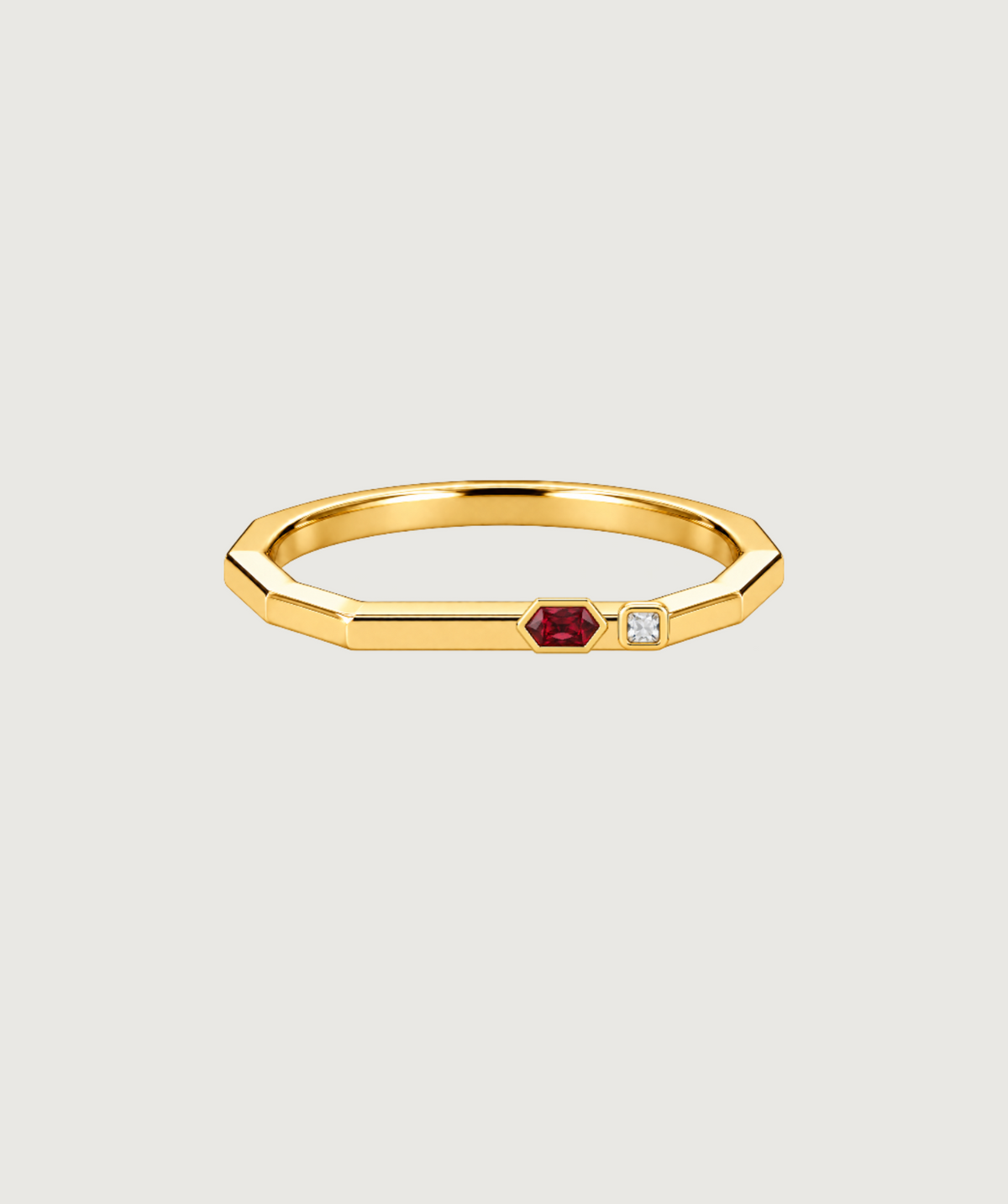 AMBECA angular stacking ring in gold tone with a wine-red hexagonal stone and small clear square stone, front view