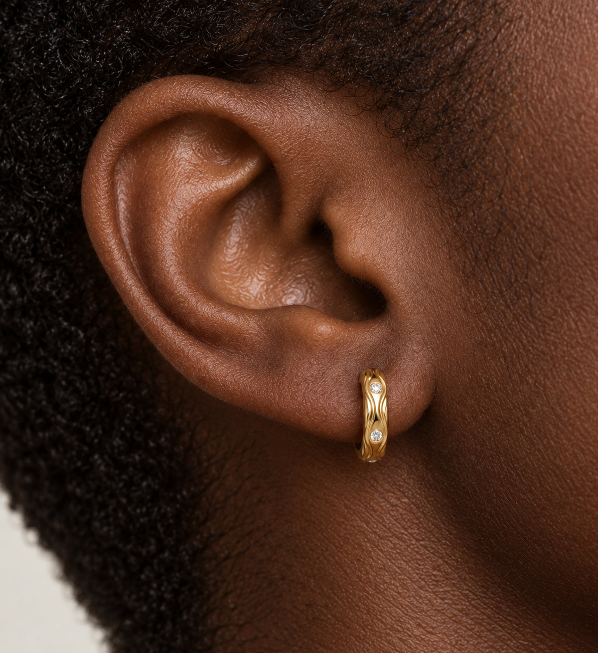 Marea Sculpted Wave Huggie Earrings (Gold), model close-up view