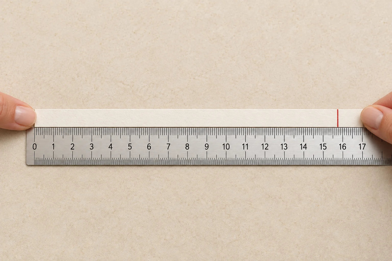 Lay a marked paper strip flat beside a ruler, starting at zero, to read your wrist measurement